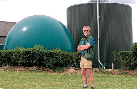 Dr Stephen Temple standing in front of his anaerobic digester